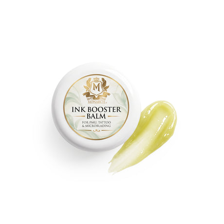 Skin Monarch Ink Booster Balm 30ml, Deckel neben einem glänzenden gelben Balsamstrich
