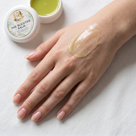 Skin Monarch Ink Booster Balm 30ml, glänzender Balsam auf dem Handrücken verteilt